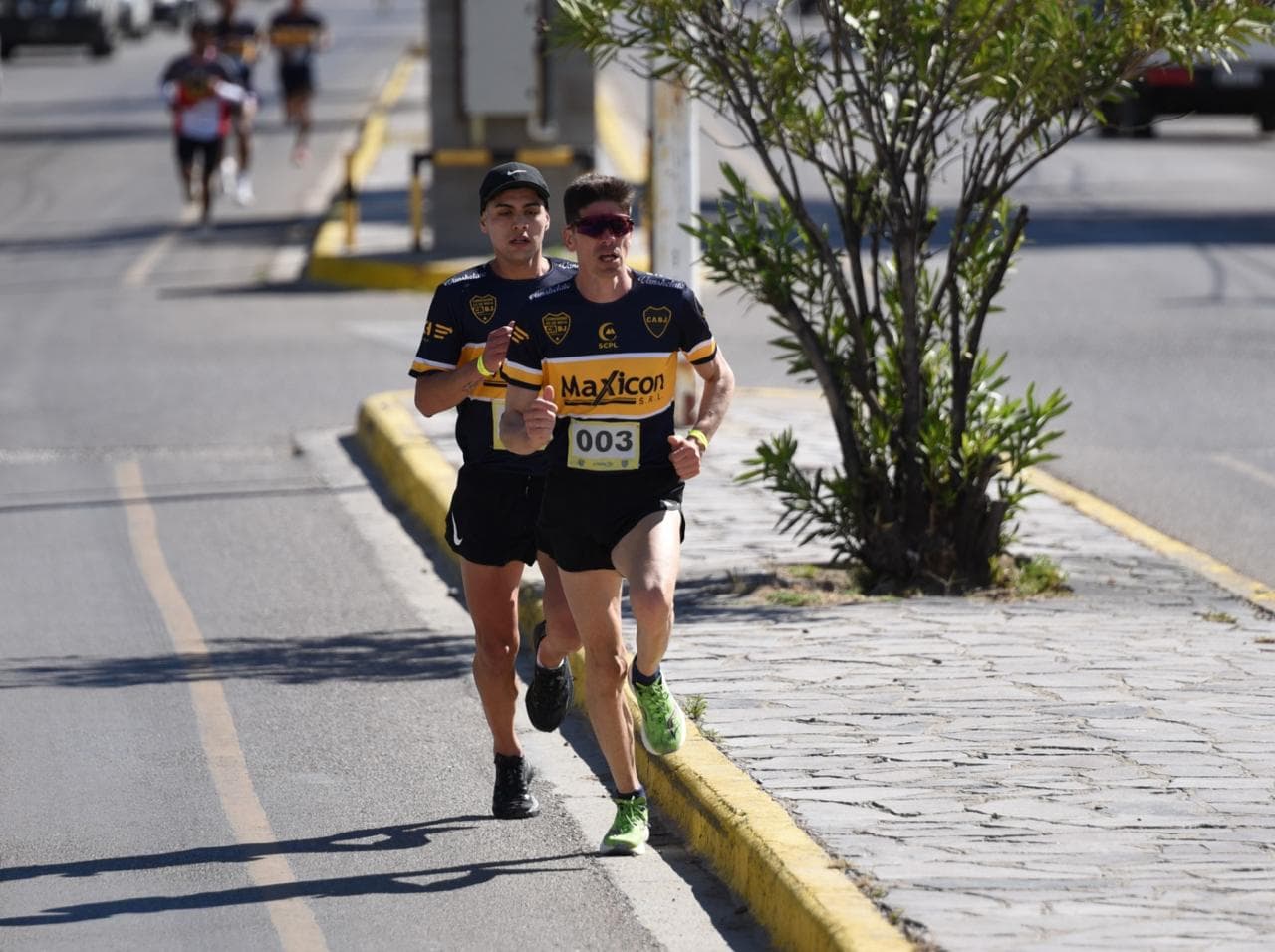 Dos corredores avanzando por la vereda durante la carrera