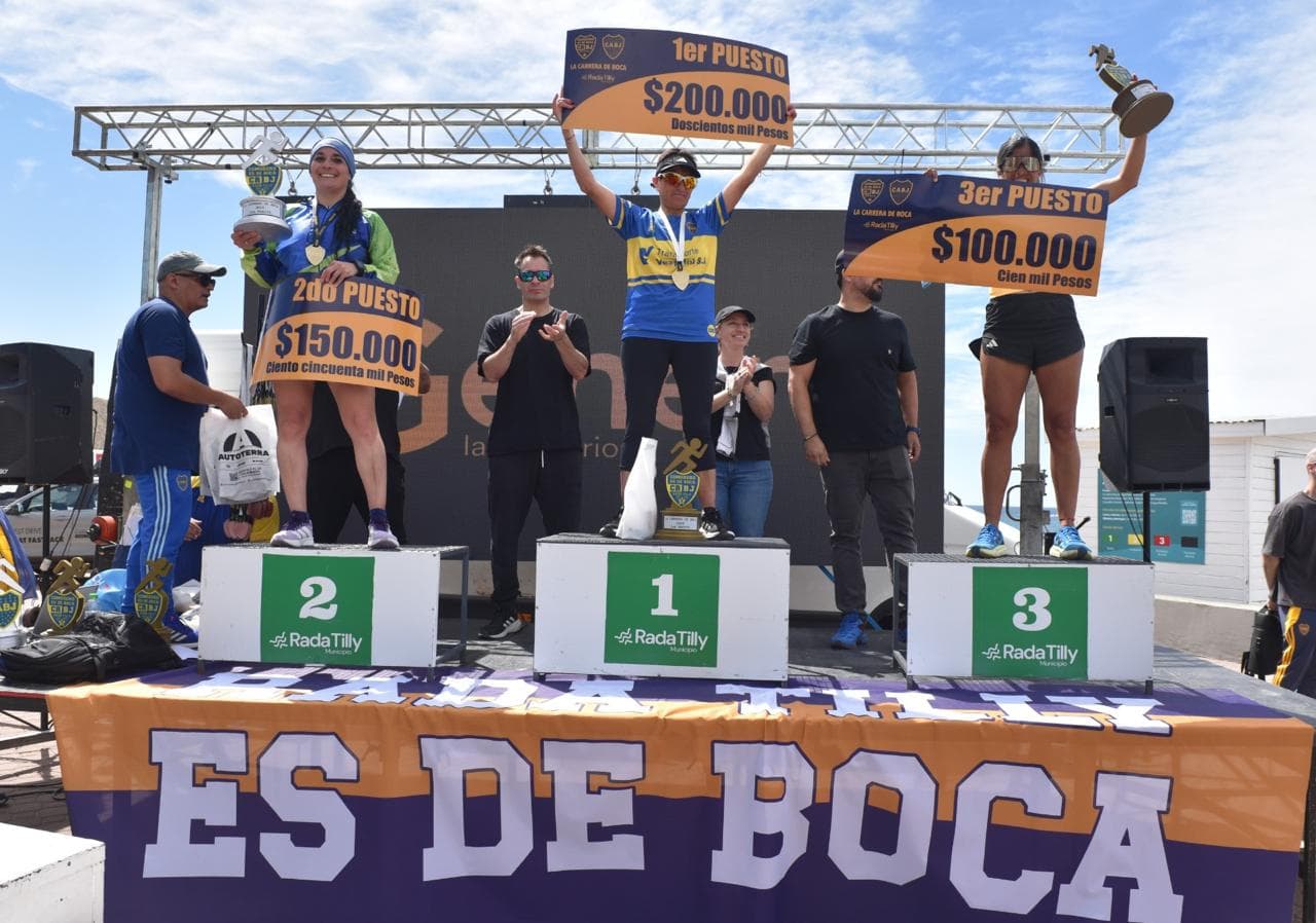 Podio femenino con los carteles de premio en la playa
