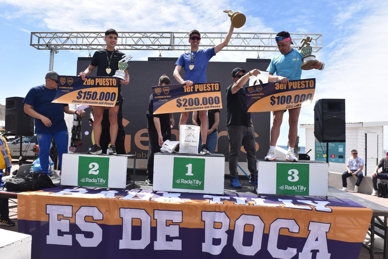 Podio masculino con los carteles de premio en la playa